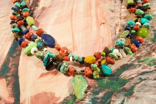 Beautiful 3 Strand Treasure Necklace with Genuine Assorted Gemstones. Featuring Genuine Turquoise, Red Jasper, Blue Lapis, Picture Jasper, Pearls and Spiny Oyster Shell. Genuine Hand Carved Turquoise Leaf Design Pendant. Penshell Heishi Spacers. Sterling Silver Cones and Clasp. Created by Santo Domingo Artist Carol Pacheco. The Santo Domingo Pueblo is in New Mexico, near Santa Fe.